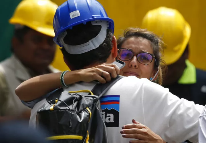 Un trabajador de rescate abraza a la novia de Jorge Gómez, de España, que espera en el sitio de búsqueda de personas que se cree están atrapadas bajo los escombros de un edificio de oficinas colapsado, incluido su novio.  /  Foto: AP
