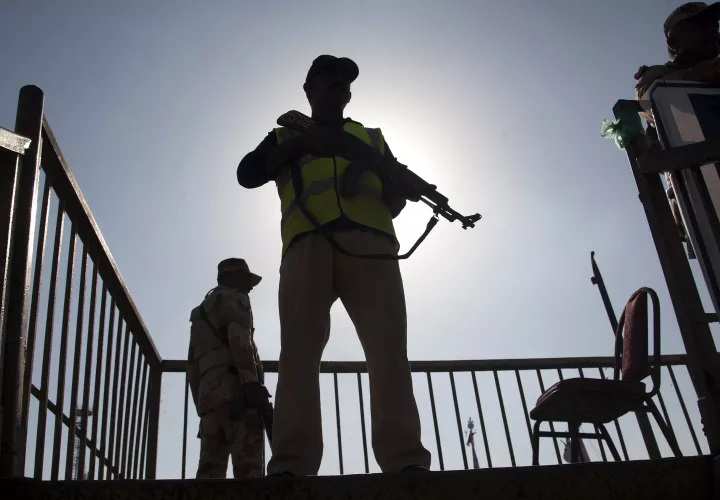Un oficial de policía y soldados paramilitares vigilan la zona desde un puente elevado para garantizar la seguridad. / AP
