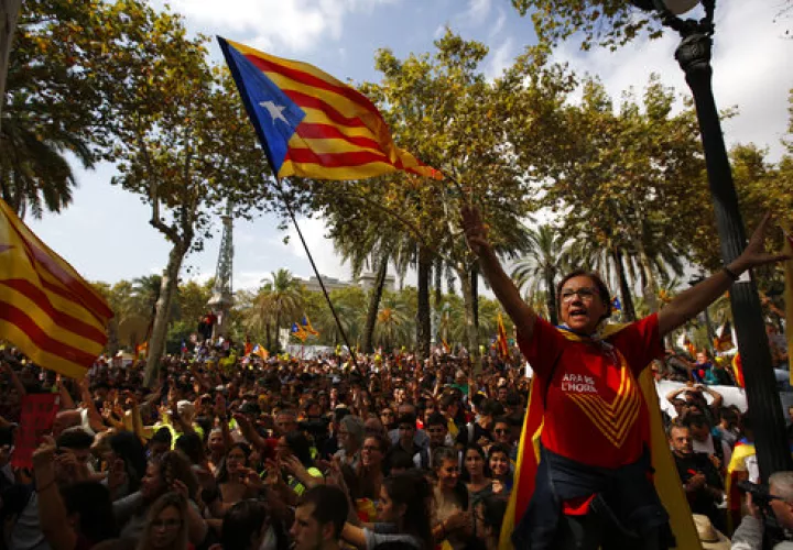 Una mujer gesticula y otros manifestantes ondean la &quot;estelada&quot;, la bandera independentista de Cataluña, durante una protesta en Barcelona, España. AP