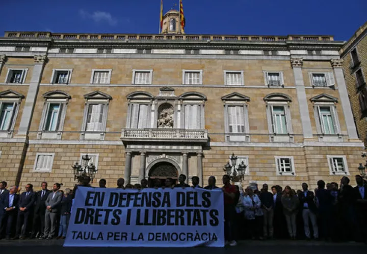 La gente sostiene una pancarta que lee en catalán: "En defensa de los derechos y libertades". Mesa para la democracia "./ AP