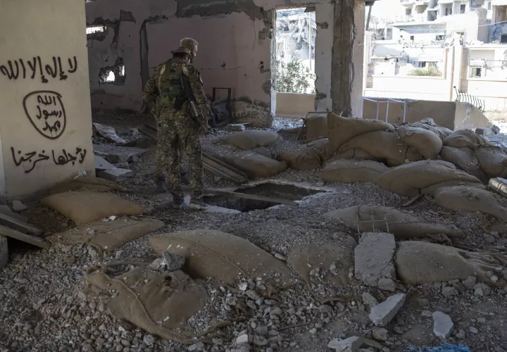 Miembros de las Fuerzas Democráticas Sirias respaldadas por los Estados Unidos comprueban si hay bombas en el estadio que fue el último puesto de los combatientes del Estado Islámico en la ciudad de Raqqa, Siria. / AP