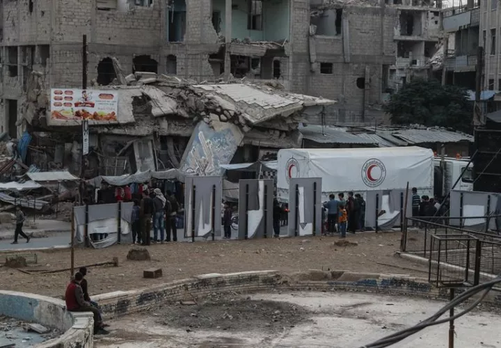 Convoys de ayuda pas por edificios destruidos en Douma, Siria.EFE