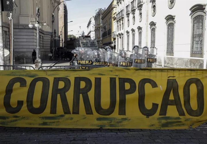 Policías brasileños vigilan una protestas frente a la Asamblea de Río de Janeiro (Brasil), donde los legisladores debatían el pasado viernes sobre el futuro del presidente de la institución y varios diputados, encarcelados por corrupción. EFE