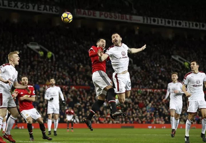 Henrikh Mkhitaryan disputa el balón ante Phil Bardsley de Burnley (dcha). Foto: AP