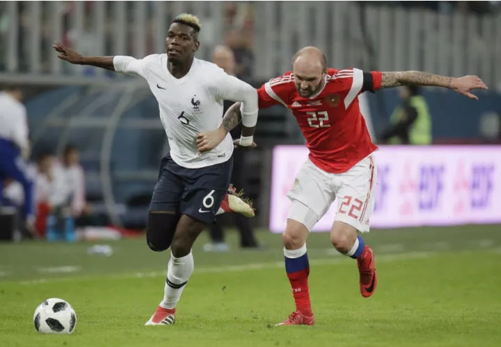 El francés Paul Pogbá (izq.) y el ruso Konstantin Rausch disputan el balón en el duelo amistoso. Foto AP