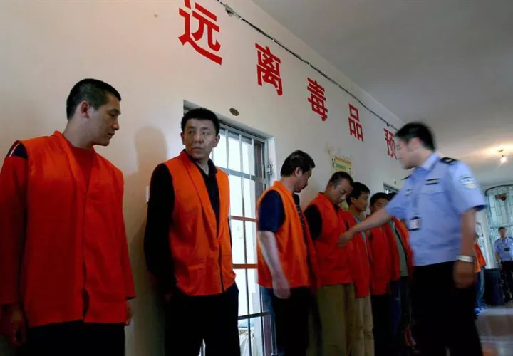 Un policía cachea a los drogadictos de un centro de rehabilitación forzada de la ciudad de Gongzhuling, en la provincia del noreste chino de Jilin. EFE/Archivo