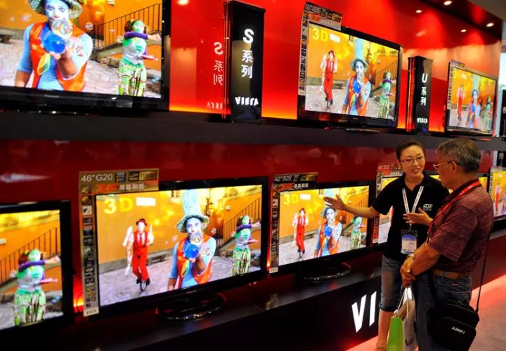 Una mujer intenta vender un televisor en Qingdao, China. EFEArchivo