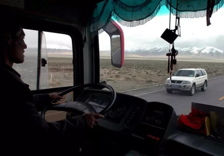 Un conductor chino conduce un autobús de pasajeros a lo largo de la carretera Qinghai Tíbet cerca de la ciudad Golmud, provincia de Qinghai, China. EFE/Archivo