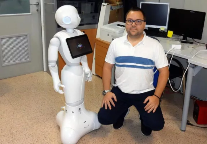 En la imagen, facilitada por la Universidad Minho, Ângelo Costa, uno de los investigadores lusos, junto al robot. EFE