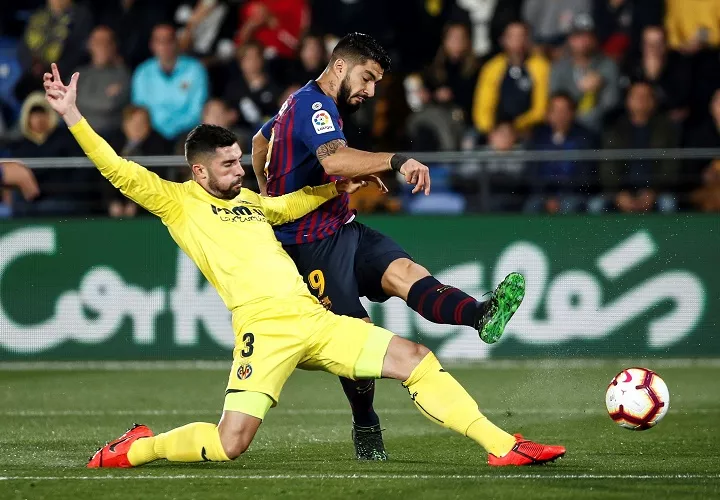 El delantero uruguayo del FC Barcelona Luis Suárez (d), dispara a puerta frente al defensa del Villarreal CF Álvaro González. Foto: EFE