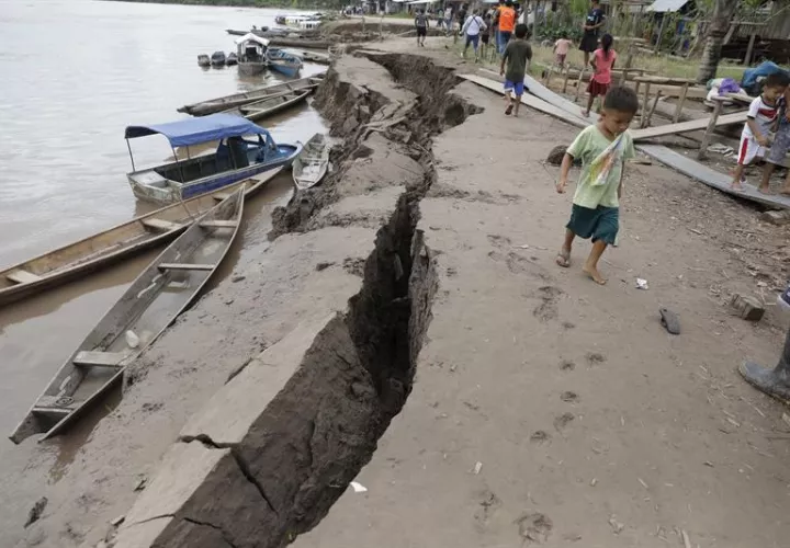 Un niño camina cerca de una grieta en el suelo, causada por un terremoto de magnitud 7,5 en la escala de Richter este domingo, en Puerto Santa Gema, en la ciudad amazónica de Yurimaguas (Perú). EFE