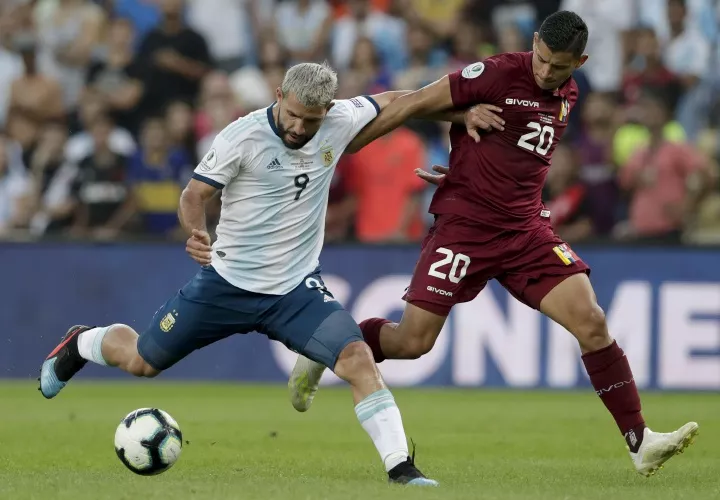 El argentino Sergio Agüero (izq.) controla bola ante la defensa del venezolano Ronald Hernández. Foto: AP