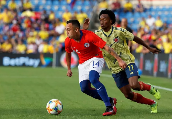 El centrocampista de Chile Fabián Orellana (i) controla el balón ante el centrocampista de Colombia Juan Guillermo Cuadrado. Foto: EFE