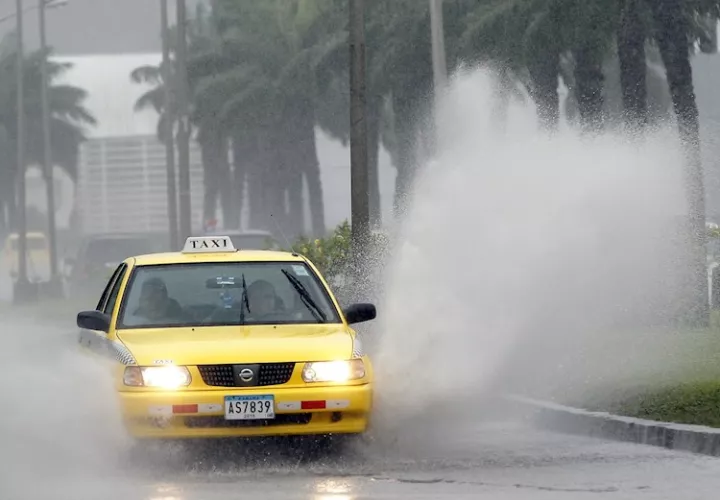 Un vehículo transita por una vía inundada