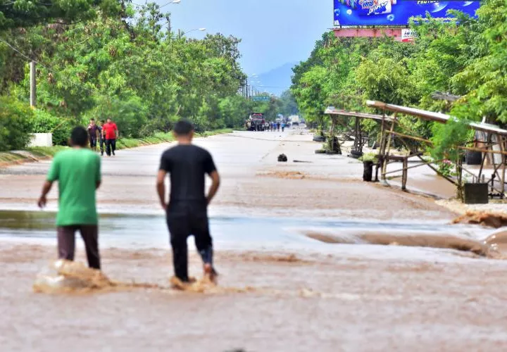 Un bombero trabajando en el rescate de un niño en una zona inundada, en la comunidad del Junquillo del departamento de Santa Bárbara (Honduras).  FOTO/EFE