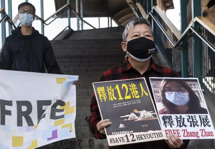 El activista por la democracia Lee Cheuk-Yan (R) sostiene carteles en apoyo a la periodista Zhang Zhan, que ha sido condenada a cuatro años de prisión. FOTO/EFE