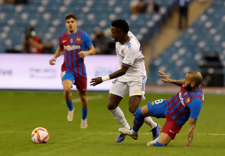  Vinicius Jr. (i), se lleva el balón ante la entrada de Dani Alves. /Foto: EFE
