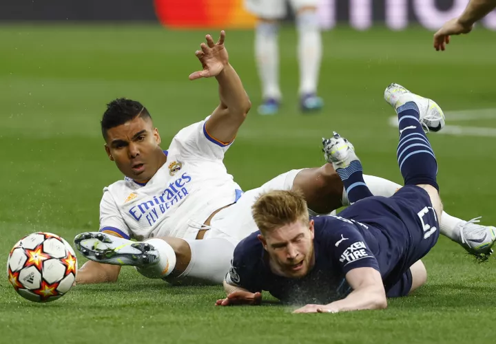 Carlos Casemiro (i) lucha con el belga Kevin De Bruyne. /Foto: EFE
