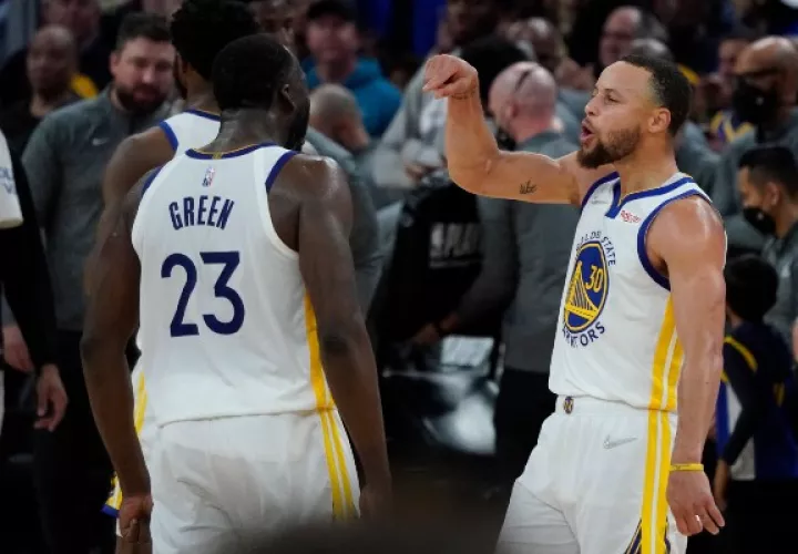 Stephen Curry (der.) celebra con su compañero Draymond Green. Foto: AP