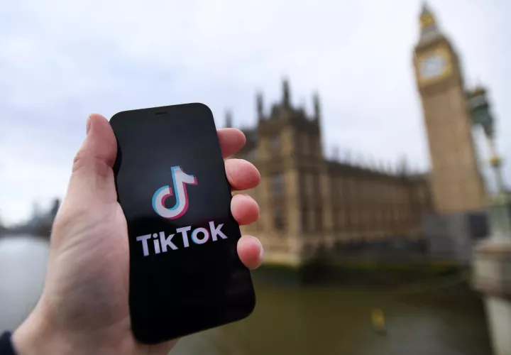 El logotipo de TikTok en un teléfono inteligente frente al parlamento británico en Londres 