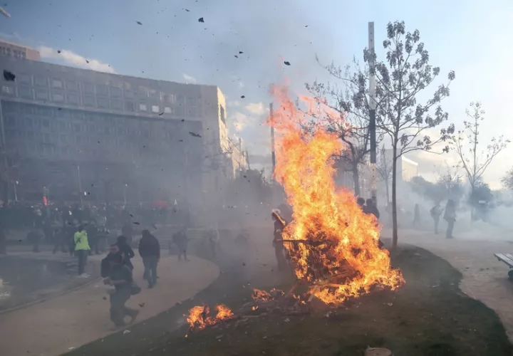 Los manifestantes encienden un fuego durante los enfrentamientos con la policía antidisturbios francesa en una manifestación contra la reforma del gobierno al sistema de pensiones en París, Francia. EFE
