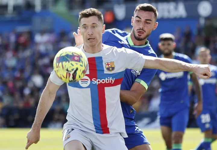 El delantero polaco del FC Barcelona Robert Lewandiwski y el defensa del Getafe Juan Iglesias, durante el duelo de ayer. Foto: EFE