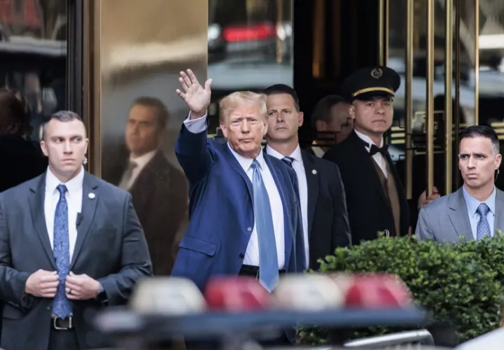 El expresidente estadounidense Donald Trump (c) saluda a la salida de la Torre Trump, en una imagen de archivo. EFE