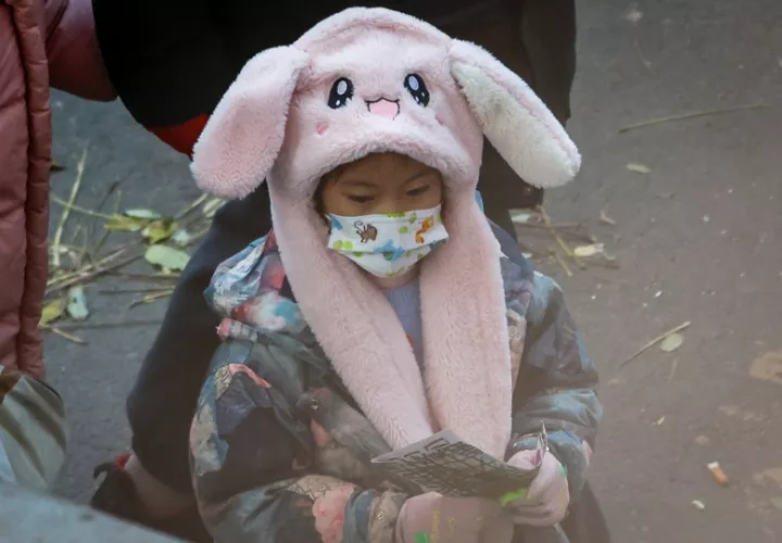 Un niño usa una mascarilla después de ser despedido de una escuela en Beijing, China