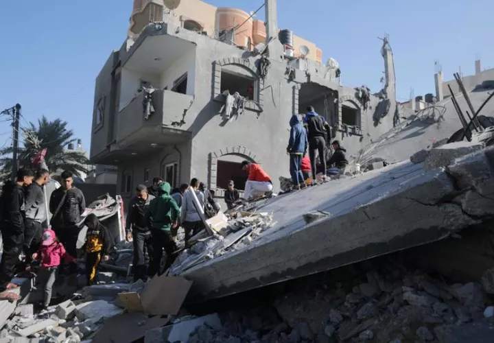 Palestinos buscan víctimas y supervivientes entre los escombros de la casa destruida de las familias Al Madfaa y Shabit tras los ataques aéreos israelíes contra el campo de refugiados de Al Maghazi, en el sur de la Franja de Gaza. EFE