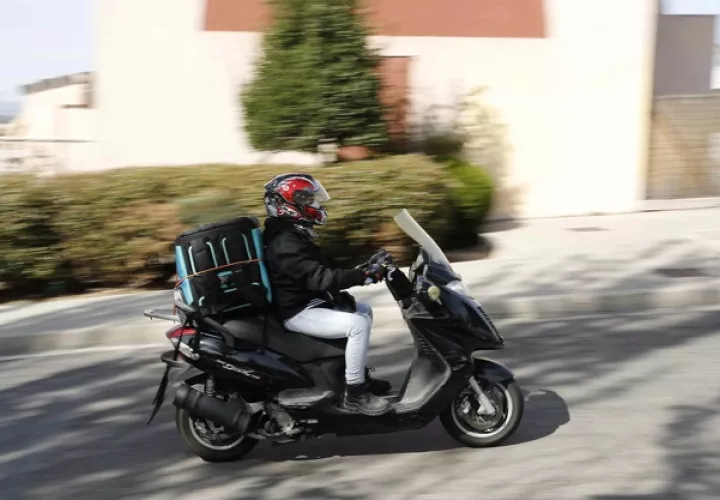 Un repartidor trabaja con su moto. EFE / Archivo