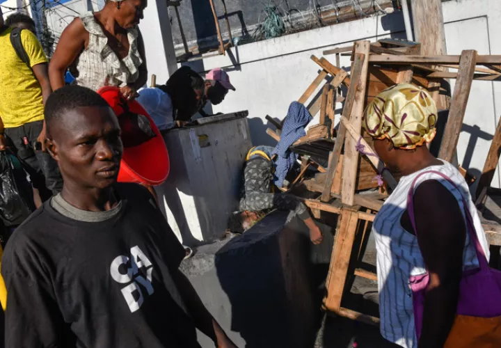 Varias personas observan el cadáver de una persona en el suelo este lunes, en Puerto Príncipe (Haití). EFE