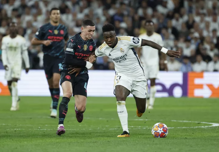 Vinicius Junior (d) protege el balón ante Phil Foden. /Foto: EFE