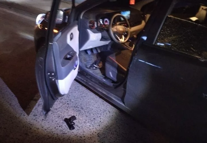 El auto interceptado y una de las tres armas decomisadas.