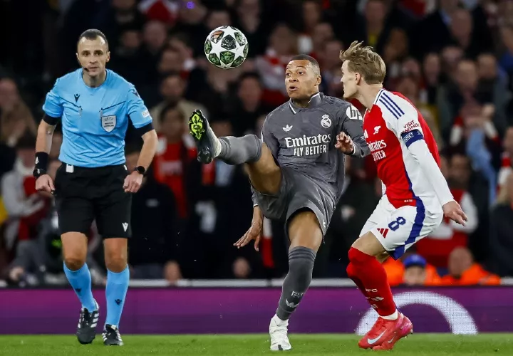 Martin Odegaard, del Arsenal, marca al atacante Kylian Mbappé, del Real Madrid.