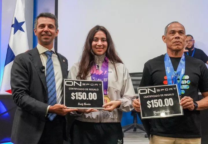 Los atletas panameños Emily Santos (c) y Gustavo Harper (der.) junto al director de Pandeportes, Miguel Ordóñez, durante la actividad.