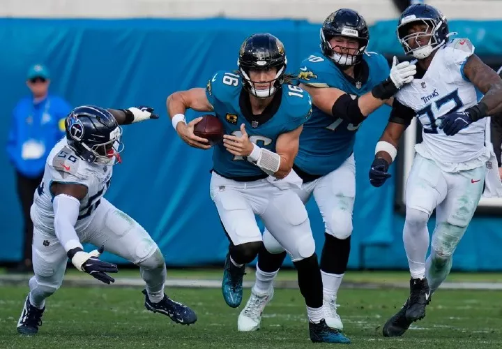 Trevor Lawrence (c) con el balón.