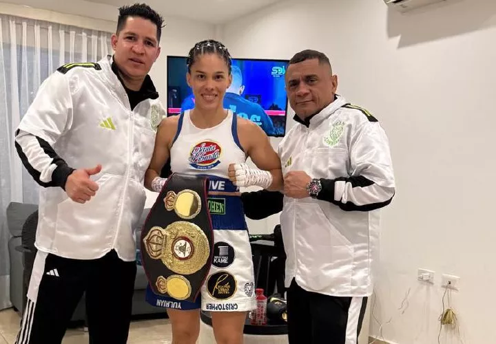 La campeona mundial supermosca de la AMB, Nataly Delgado (c), su entrenador Julio César Archibold (der.) y Héctor Manzanilla.