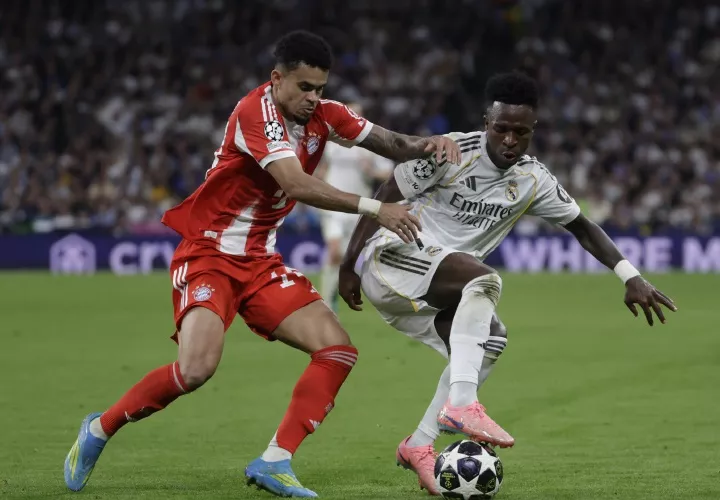 El delantero del Real Madrid, Vinicius Jr. (d), lucha con Luis Díaz, del Bayern Munich, durante el encuentro de ayer.