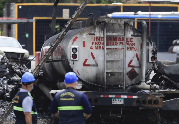 Inspeccionan donde ocurrió incendio de dos camiones de combustible.
