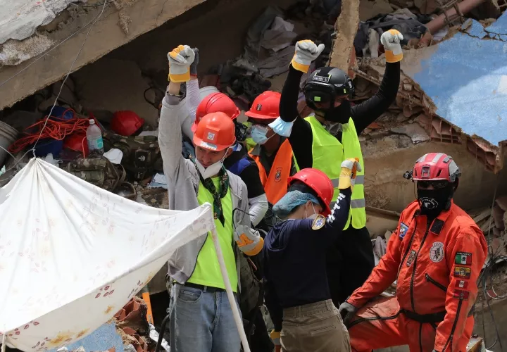 Rescatistas reaccionan en medio de escombros de edificaciones destruidas en La Guaira (Venezuela).