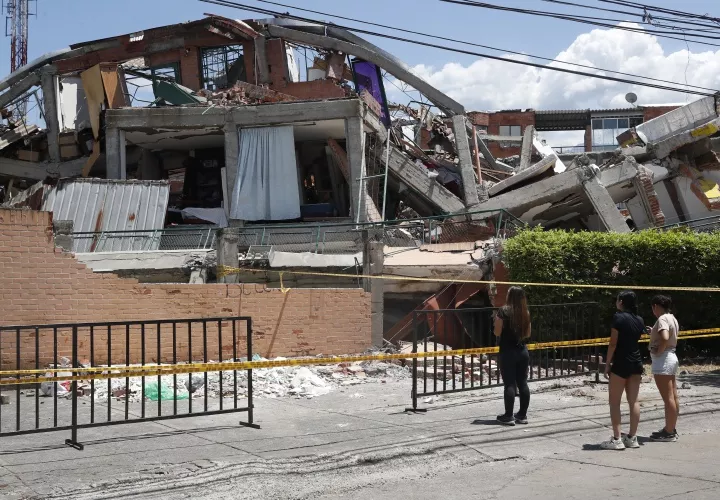 Un grupo de mujeres observa los escombros de una edificación destruida por el terremoto de magnitud 7,4 en Cali.