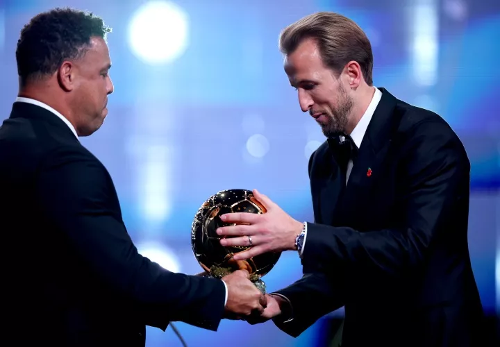 La leyenda brasileña Ronaldo Nazario de Lima (izq.) entrega el trofeo del Balón de Oro al inglés Harry Kane.
