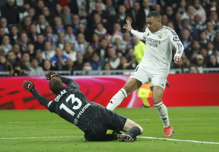 Kylian Mbappé (d) trata de superar al portero Jan Oblack. /Foto:EFE