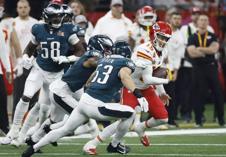 El quarterback Patrick Mahomes (R) trata de evadir a la defensiva de los Eagles. /Foto: EFE