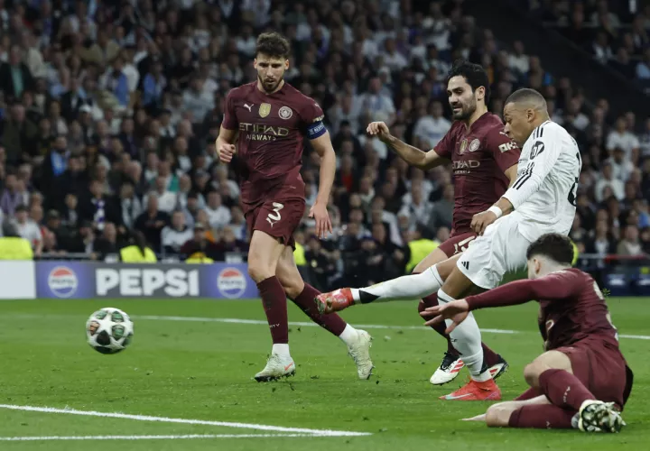 Kylian Mbappé (2d), remata ante los defensores del Manchester City. /Foto: EFE