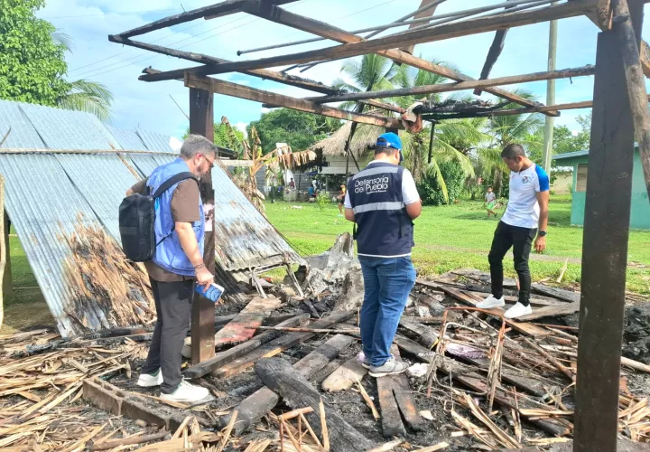 Personal de Defensoría inspecciona el rancho incendiado durante las proetstas.
