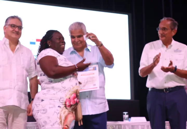 Presidente Mulino entrega llave a una de las beneficiarias.