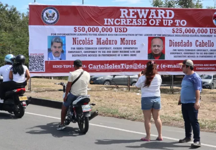 Personas observan una valla con la imagen del presidente de Venezuela, Nicolás Maduro, y del ministro de Relaciones Interiores, Justicia y Paz de Venezuela. Foto: EFE