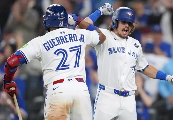 Addison Barger (der.) es saludado por Vladimir Guerrero Jr., luego de conectar un jonrón con bases llenas. Foto: EFE