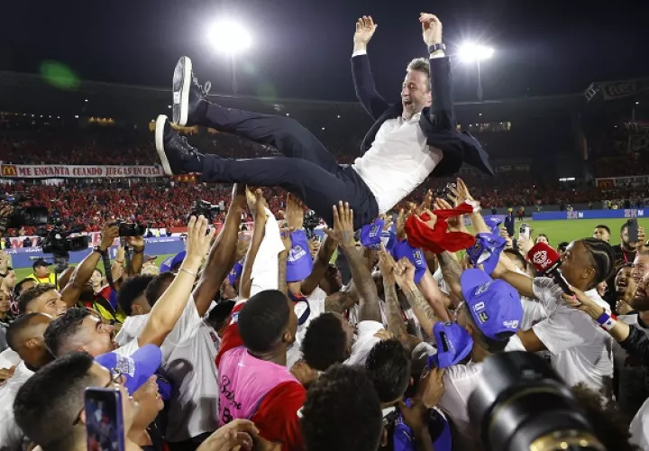 El técnico Thomas Christiansen es levantado por sus jugadores luego de la clasificación. Foto: EFE